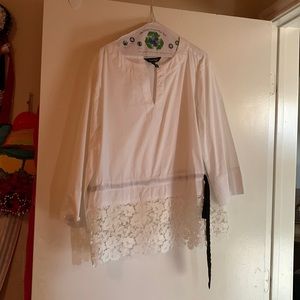 A white handmade shirt with a white floral lace and a black ribbon